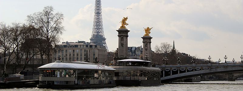 Restaurang vid floden Seine och broarna med Eiffeltornet i bakgrunden, Paris.